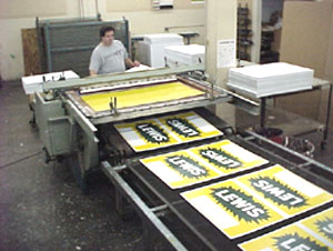 more elaborate press that auto feeds signs straight to conveyer built where it is dried
